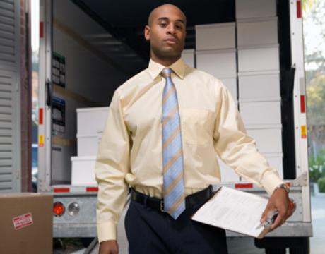 image of man in business attire, in front of moving truck